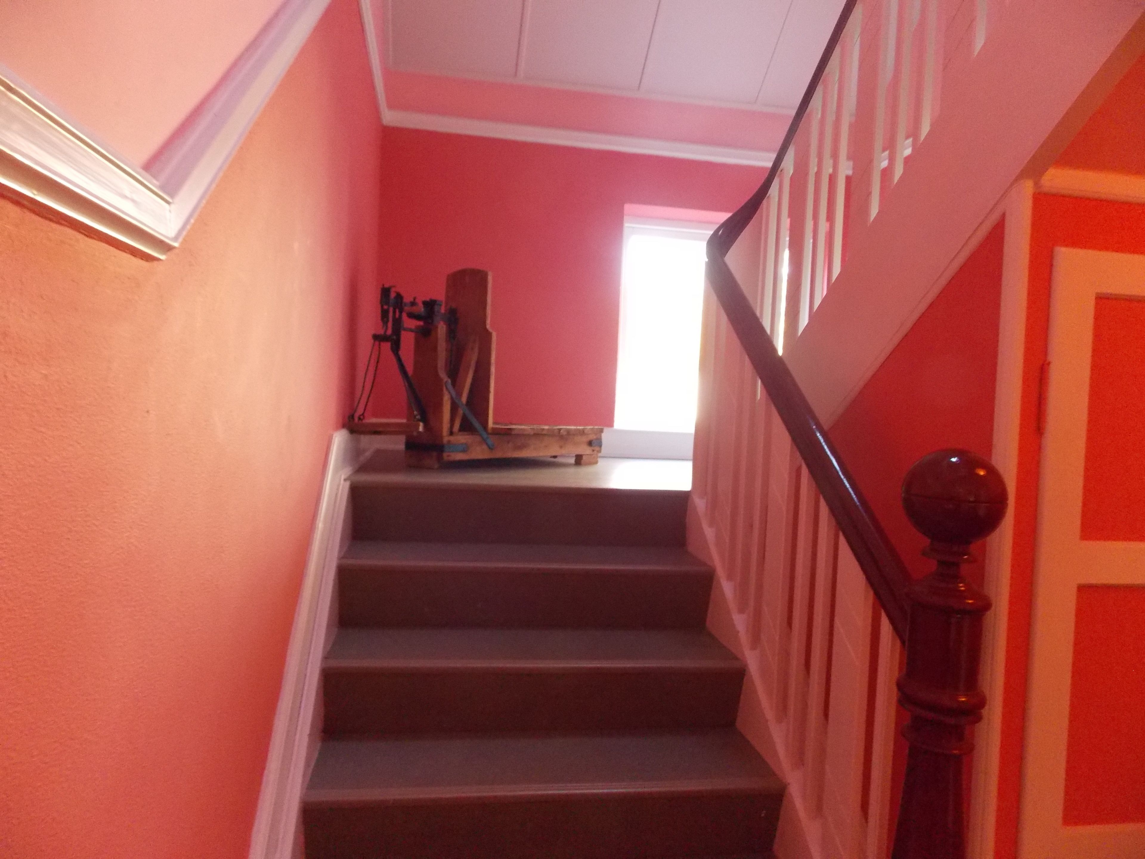 A staircase with a wooden handrail and a wooden banister.