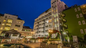 A multi-story hotel with balconies and a swimming pool area. - Sutus Court 1 (Pattaya)