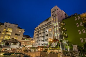 Experience the sleek, multi-story hotel with expansive balconies and a stunning pool view.