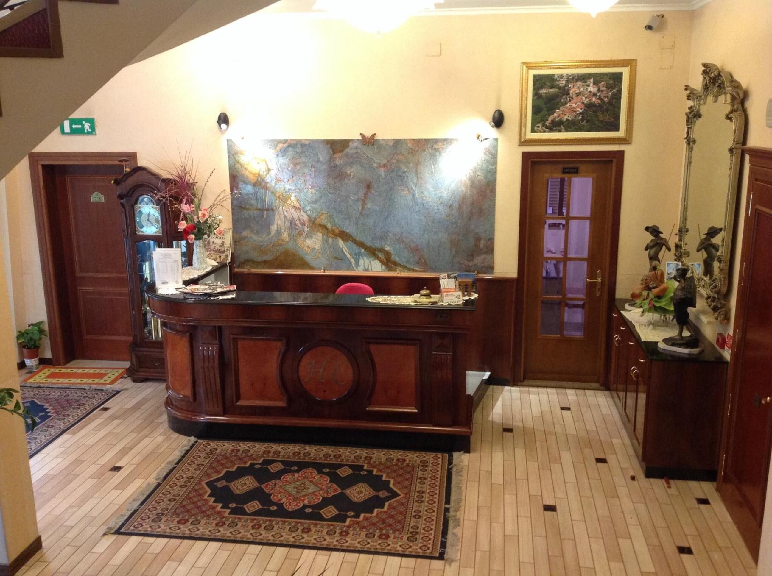 A reception area with a wooden desk, a large abstract painting, a clock, and a door with a glass panel.