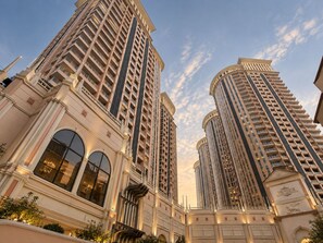 A high-rise building with multiple floors, large windows, and a classical architectural style. - MaxStays Max Pavilion at The Venice Residences (Taguig)