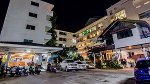 A multi-story hotel with a ground-level restaurant and several parked vehicles. - Sutus Court 3 (Pattaya)