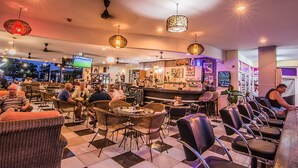 A bar area with wicker chairs, a checkered floor, and pendant lighting. - Sutus Court 3 (Pattaya)