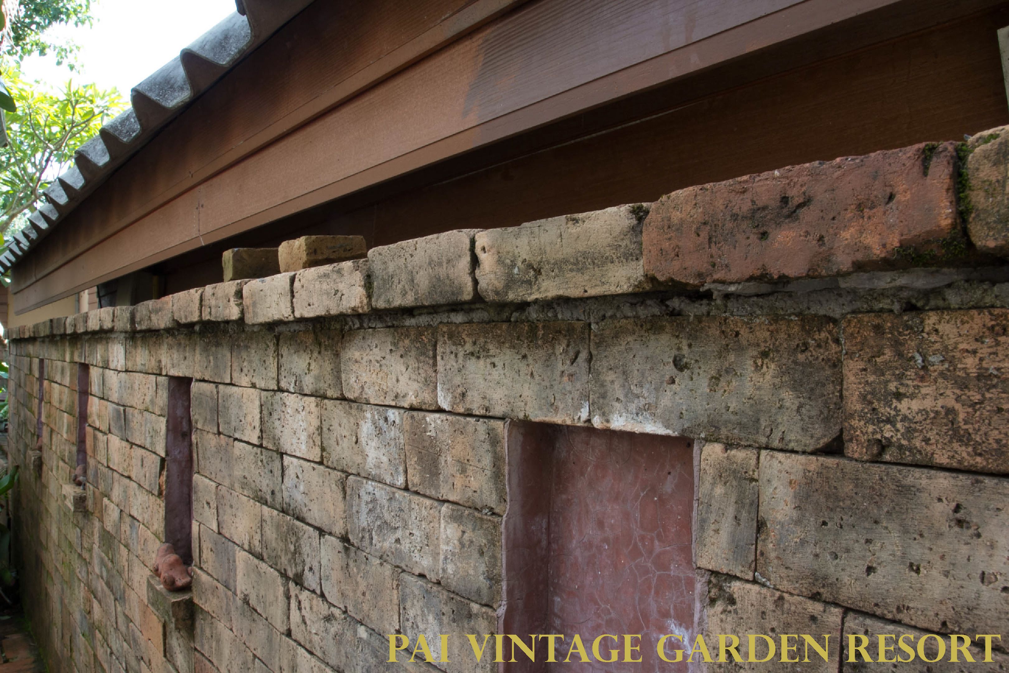 A brick wall with a wooden beam above it.