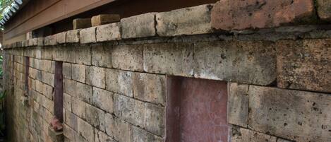 A brick wall with a wooden beam above it.