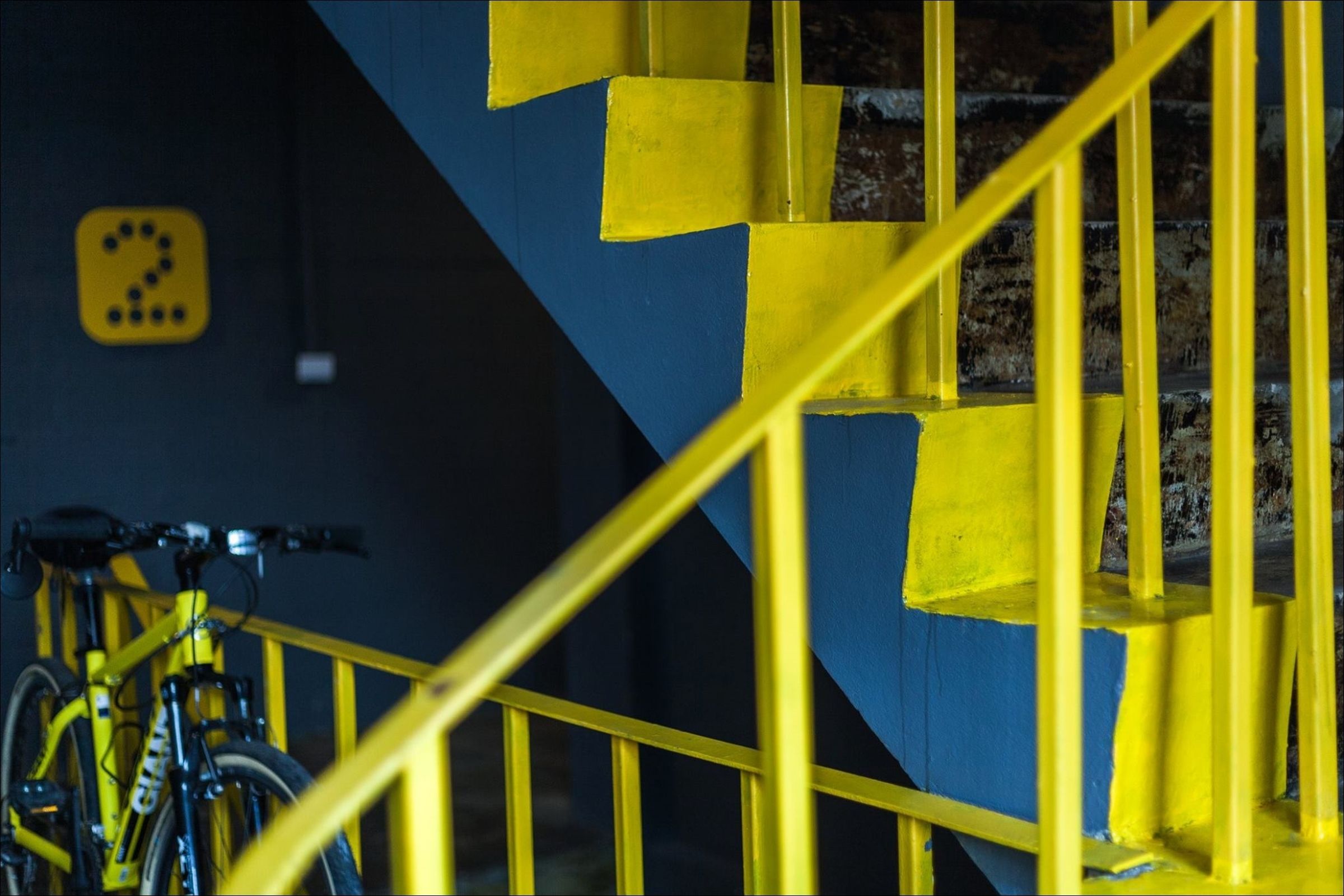 A staircase with yellow railings and a bicycle parked nearby.