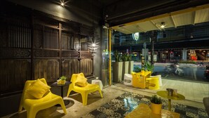 Un interior moderno con paneles de madera tradicionales, sillas amarillas y suelo estampado.
