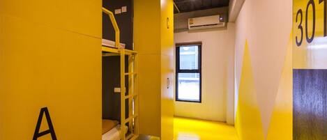 A narrow hallway with yellow walls, a bunk bed, and a door labeled "301".