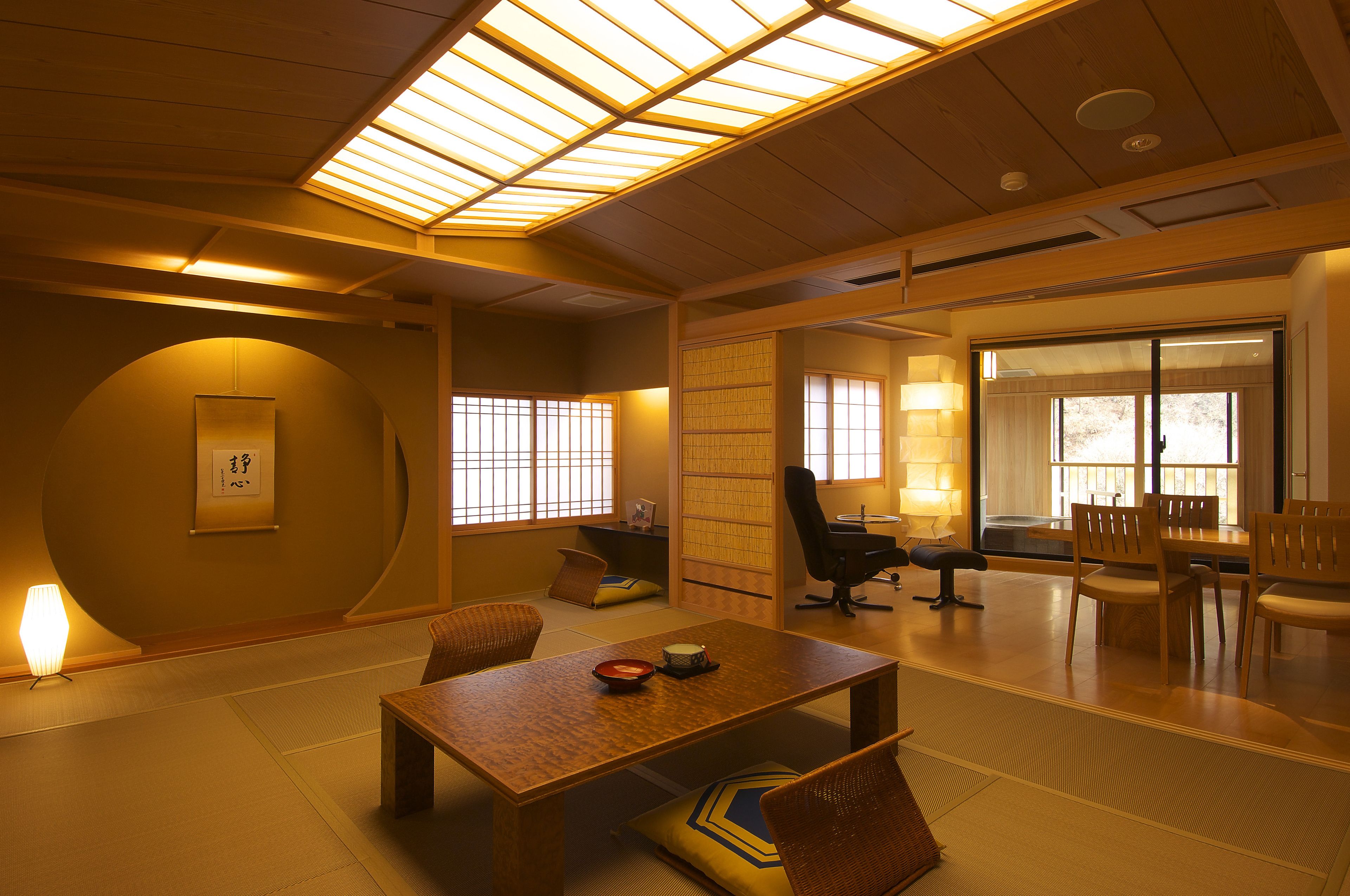A traditional Japanese room with tatami flooring, a low wooden table, and a sliding door leading to another room.