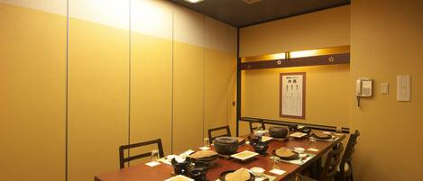 A conference room with a long table set for a meeting, equipped with chairs, a projector, and a whiteboard.