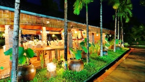 A restaurant with outdoor seating, surrounded by palm trees and potted plants. - Sen Viet Phu Quoc Resort Sport & Spa (Phu Quoc)
