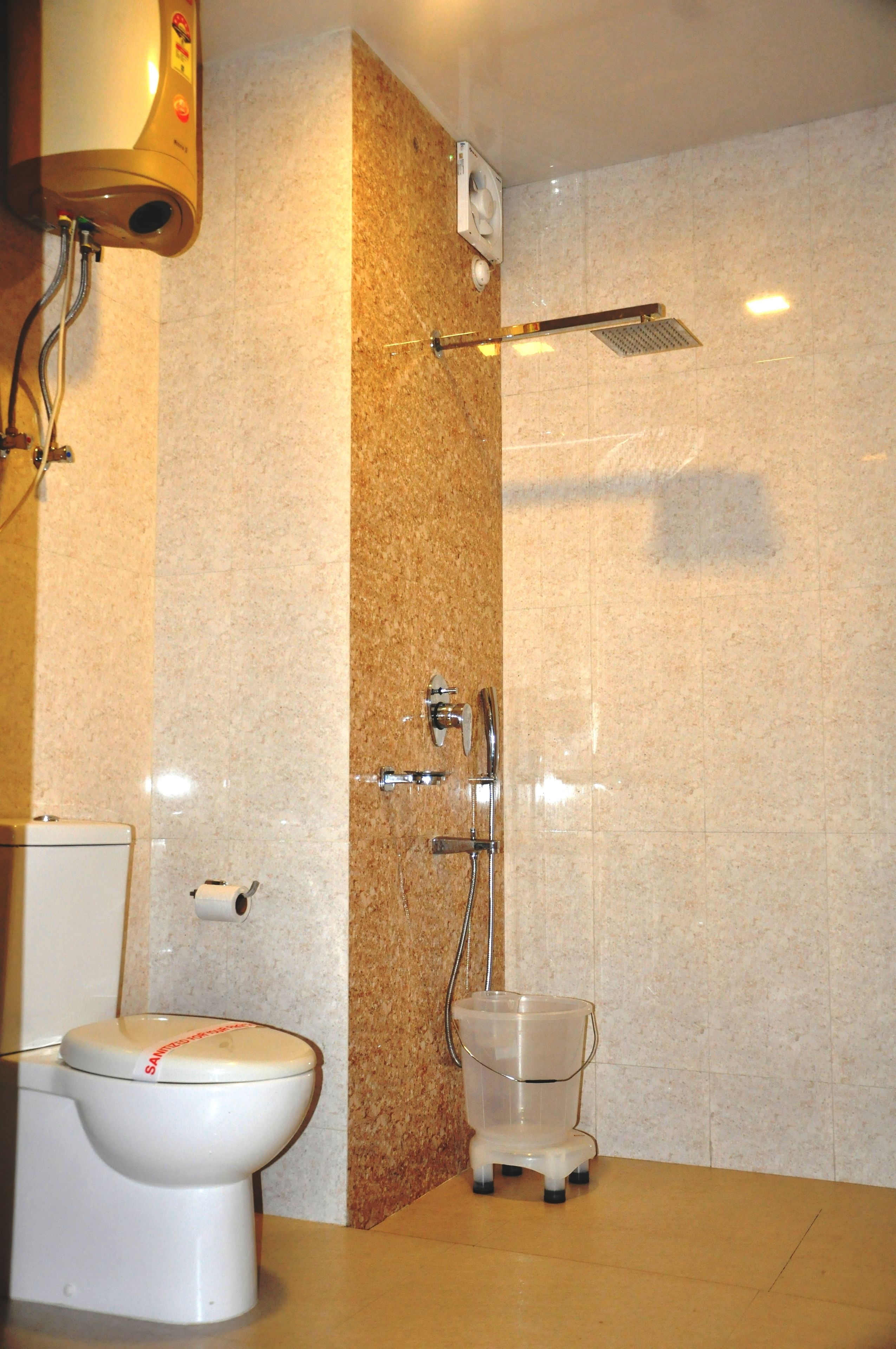 A bathroom with a toilet, a shower, and a sink.