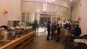 Un espace buffet avec différents stands de nourriture et une cloison décorative en verre.