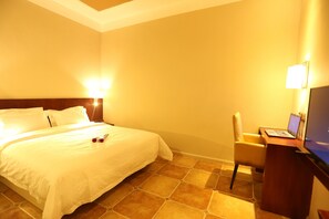 A hotel room with a large bed, a desk with a laptop, and two wall-mounted lamps. - Cheng Yue Selected Hotel Guangzhou Junye Nangang Branch (Guangzhou)