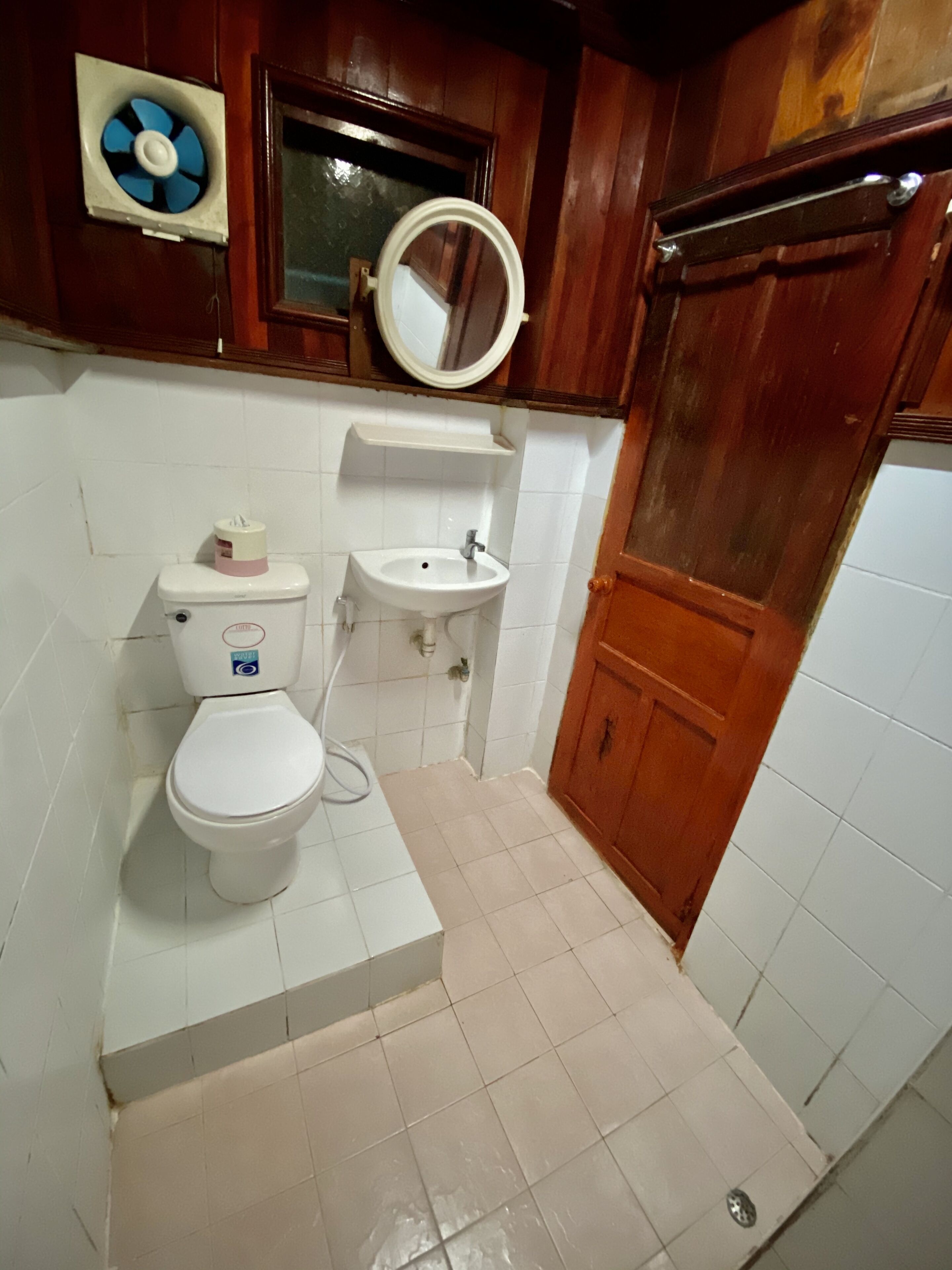 Un baño con inodoro, lavamanos y espejo.
