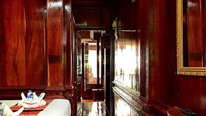 A narrow hallway with wooden walls and a bed on the left. - Soutikone 1 Guesthouse (Luang Prabang)