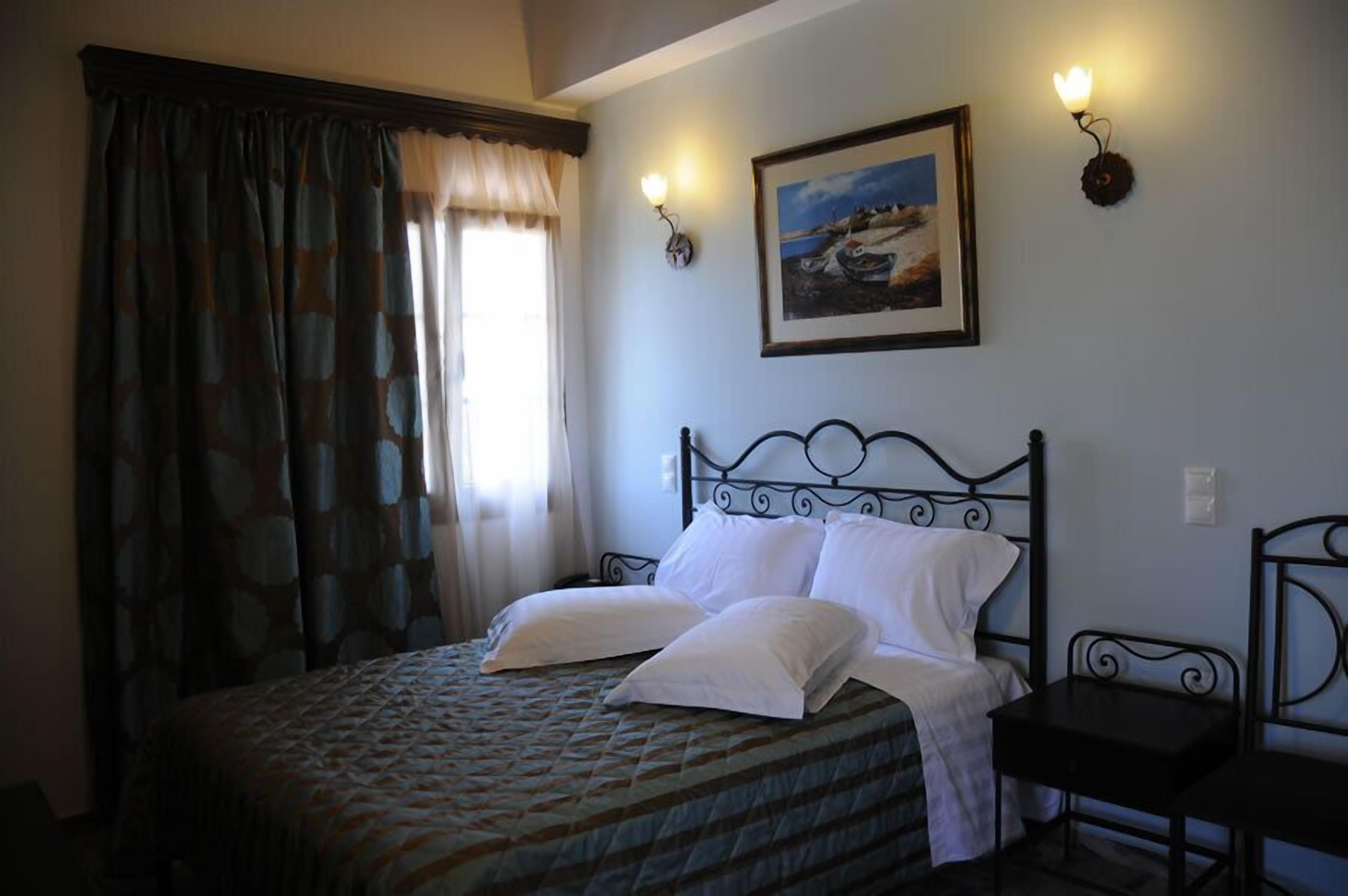Una camera da letto con un letto, due comodini, un quadro appeso al muro e una finestra con tende.