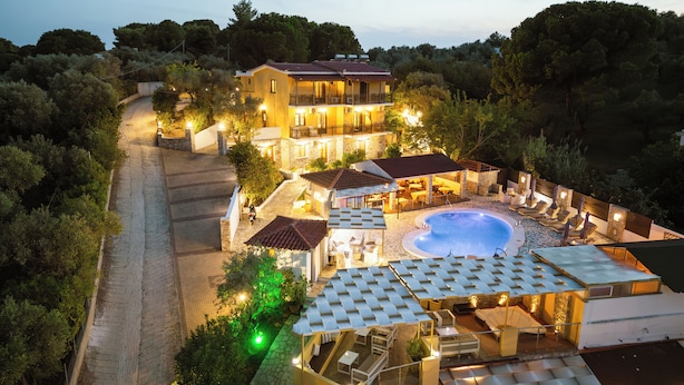 A villa with a swimming pool, outdoor seating, and a stone pathway. - Skiathos Island Suites (Skiathos)