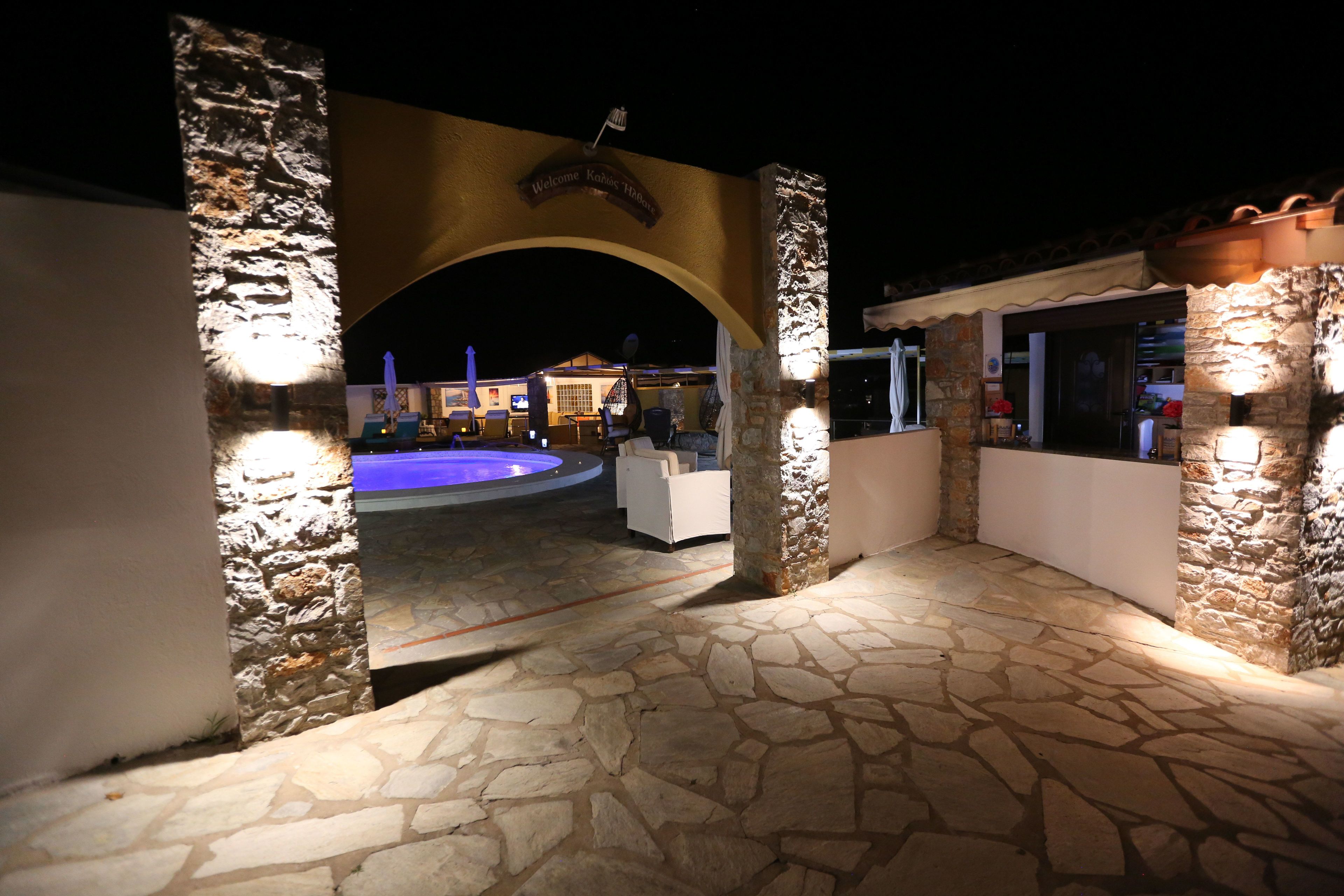 Un espace extérieur doté de murs en pierre, d’une piscine et d’un coin bar.