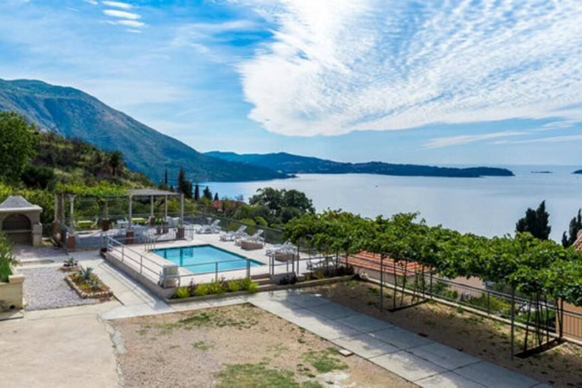 A pool area with a view of a lake and mountains.