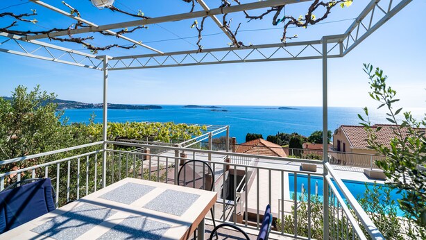 A terrace with a view of the sea, a pool, and a pergola with vines. - Apartments Klis (Zupa dubrovacka)
