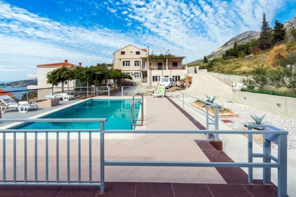 A swimming pool with a view of a hillside and a building in the background.