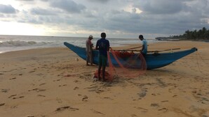 A beach with a blue boat and people around it. - Ocean Breeze Villa (Boossa)