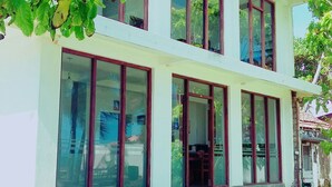 A two-story building with large windows and a flat roof. - Ocean Breeze Villa (Boossa)