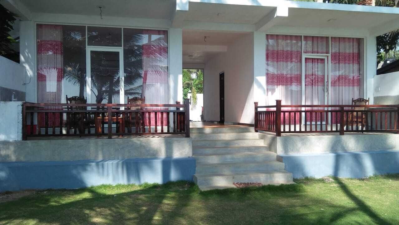 A two-story house with a balcony, a staircase leading to the upper floor, and a covered porch area.