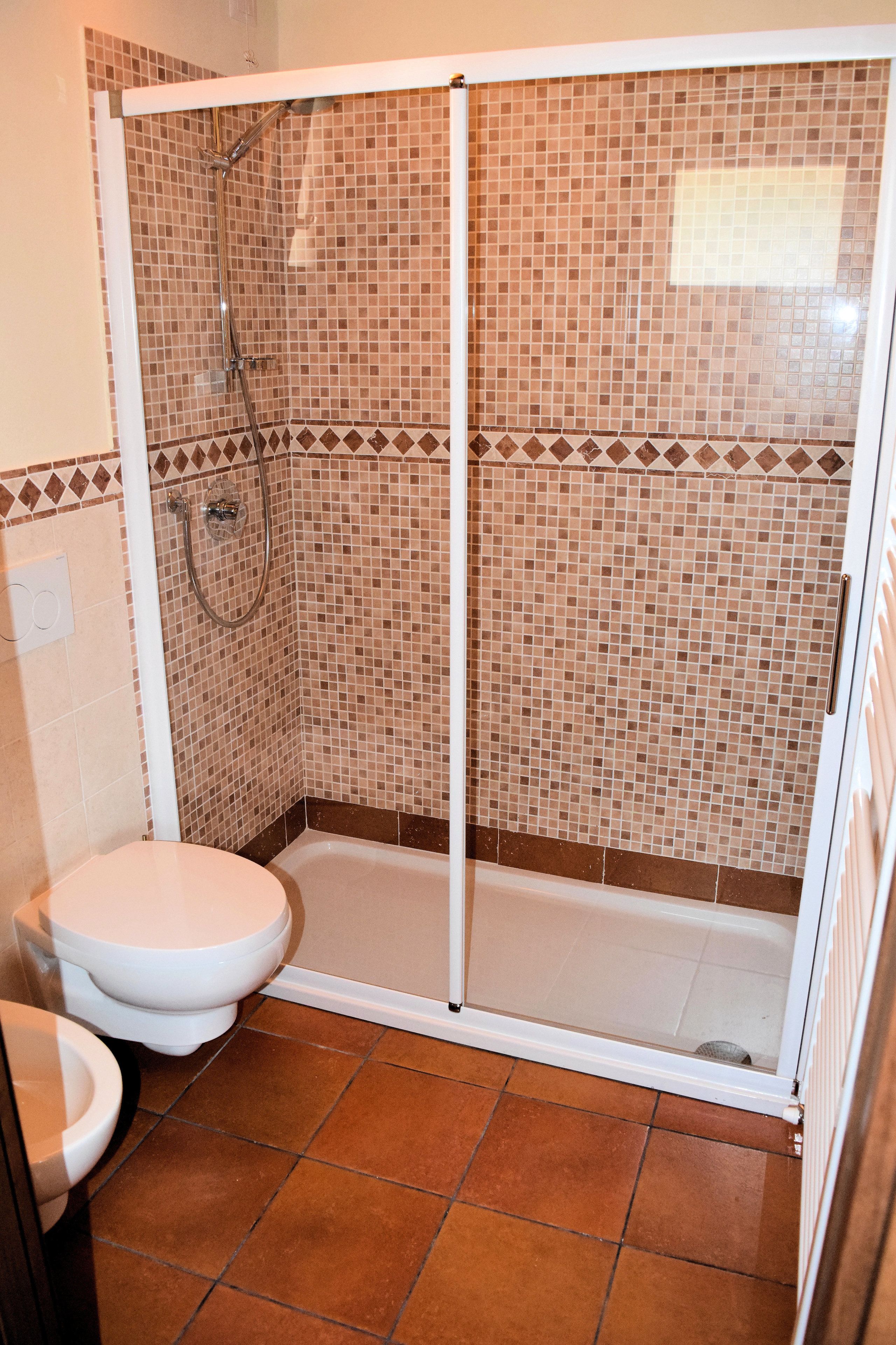 Un bagno con box doccia, WC e lavandino.