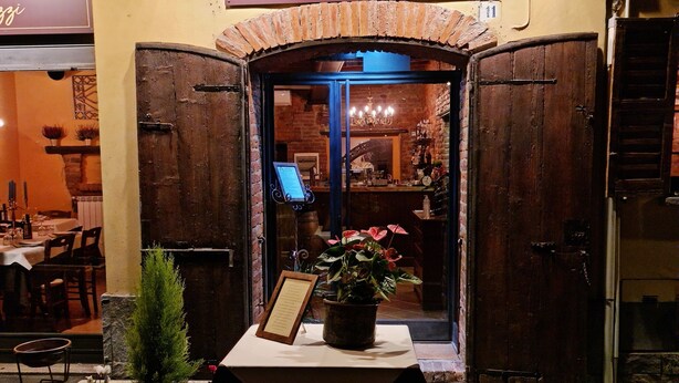 A restaurant named 'Asteria Acasa Mia' with a rustic entrance, a table with a menu, and potted plants outside. - Corte Certosina (Trezzano sul Naviglio)