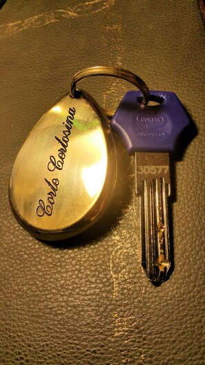 A key with a heart-shaped keychain and a purple tag. - Corte Certosina (Trezzano sul Naviglio)