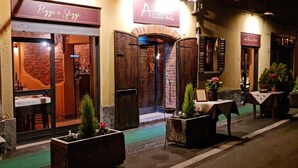 A street view of a restaurant with outdoor seating, a brick facade, and a sign reading "Pizza e Sfrizzi." - Corte Certosina (Trezzano sul Naviglio)
