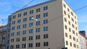 A multi-story building with a uniform facade, multiple windows, and a pedestrian crossing sign. - Grand Hotel Empire Frankfurt (Frankfurt)