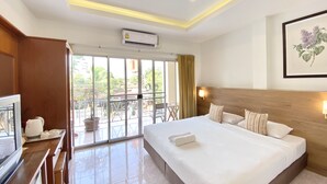 A hotel room with a large bed, a TV, a balcony with a view, and an air conditioning unit. - Pensiri House (Sa Khu)