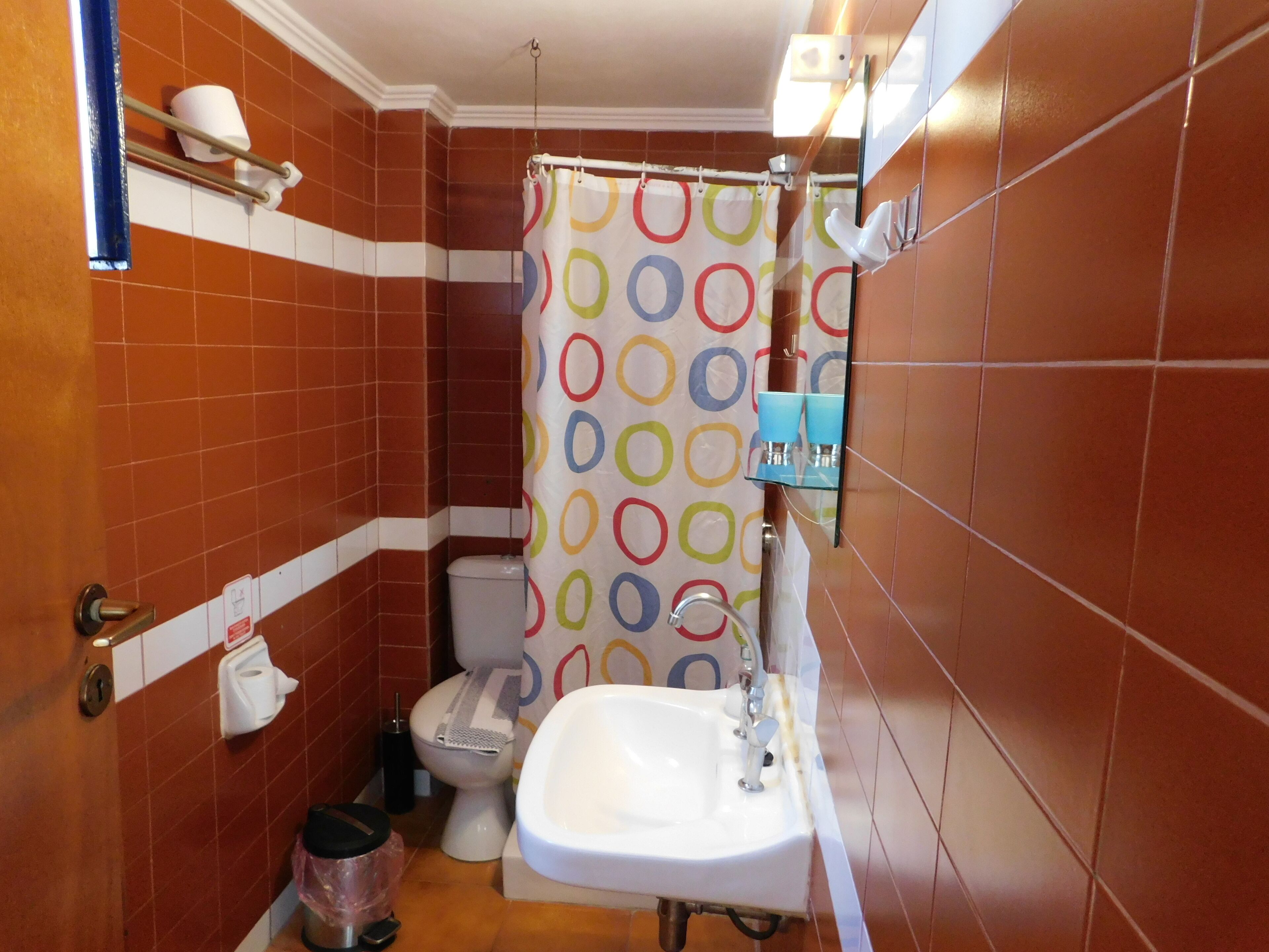 A bathroom with a toilet, sink, and shower curtain.