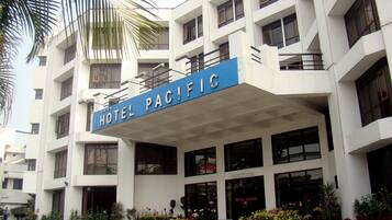 A multi-story building with a sign reading "HOTEL PACIFIC".