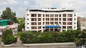 A multi-story hotel with a central atrium and a blue sign indicating it is a hotel.