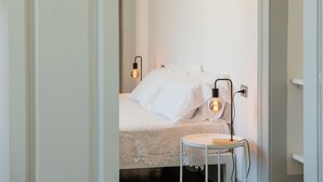Ein Schlafzimmer mit einem Bett, einem Nachttisch und zwei Wandleuchten.
