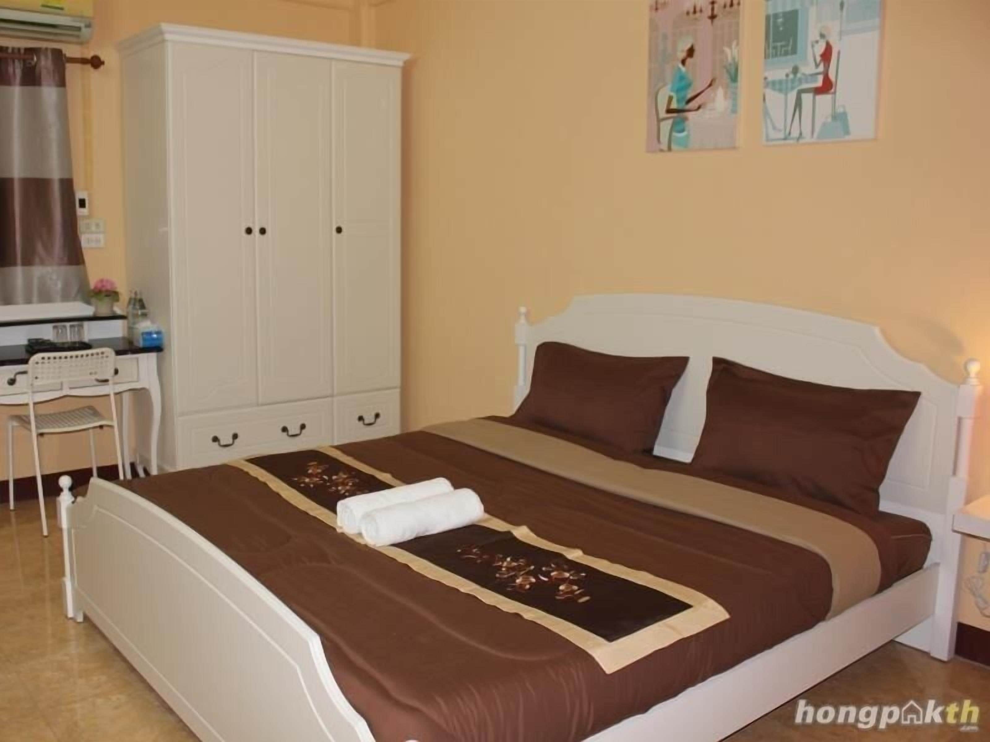Un dormitorio con cama, escritorio y armario.