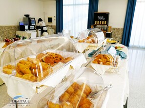 Un bufé con diversos productos horneados, una máquina de café y un cartel que dice 'Prueba la frescura'.