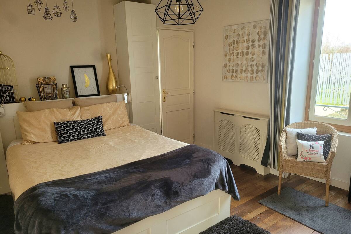 Een slaapkamer met een bed, een stoel, een radiator en een raam.