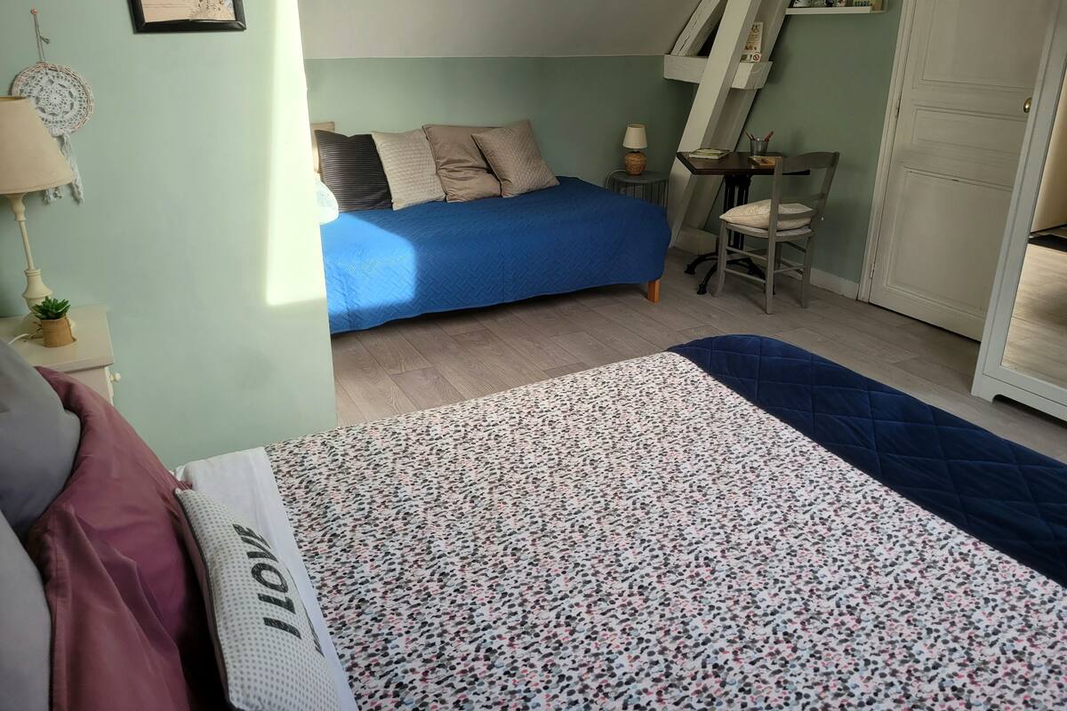 Een slaapkamer met een bed, een bureau en een stoel.