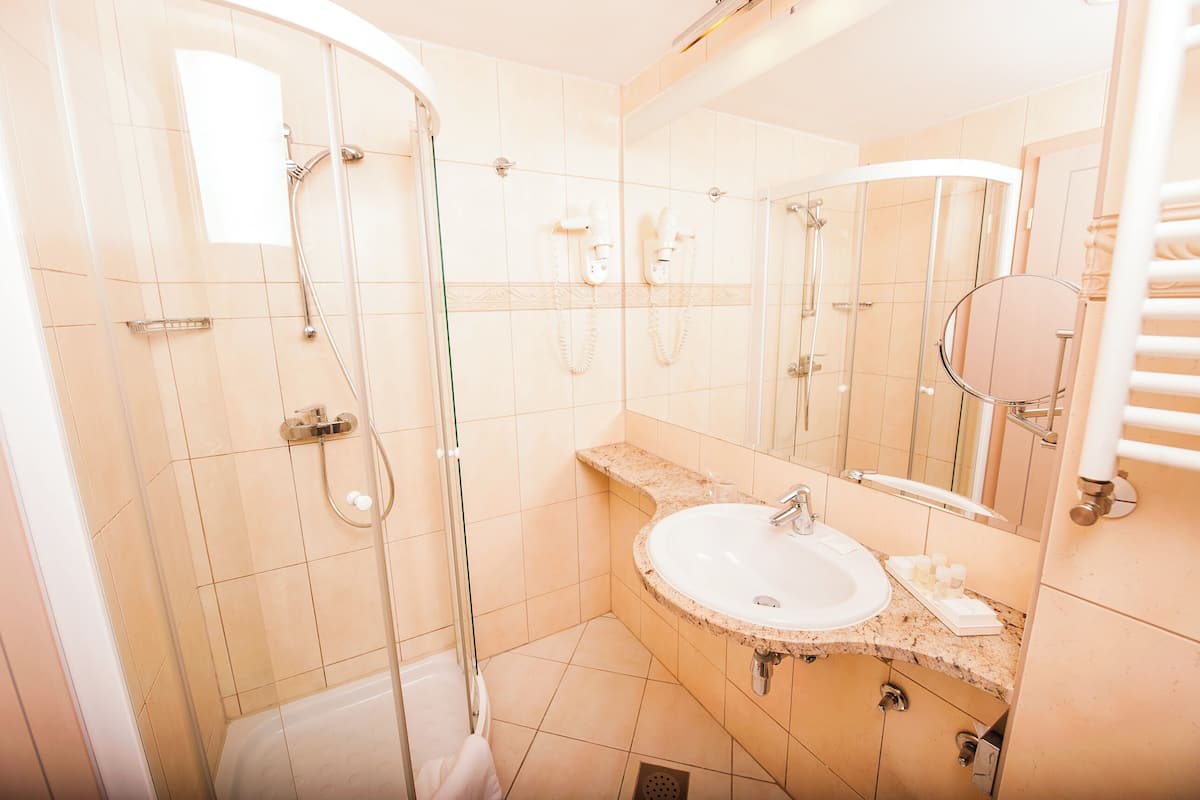 Une salle de bain avec une douche à parois de verre, un lavabo et un miroir.