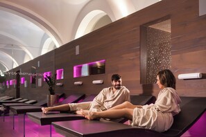 A spa area with massage tables, a wall with a textured pattern, and a ceiling with a circular design. - Grand Hotel Sava (Rogaska Slatina)