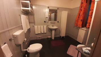 Une petite salle de bain comprenant des toilettes, un lavabo et un miroir.