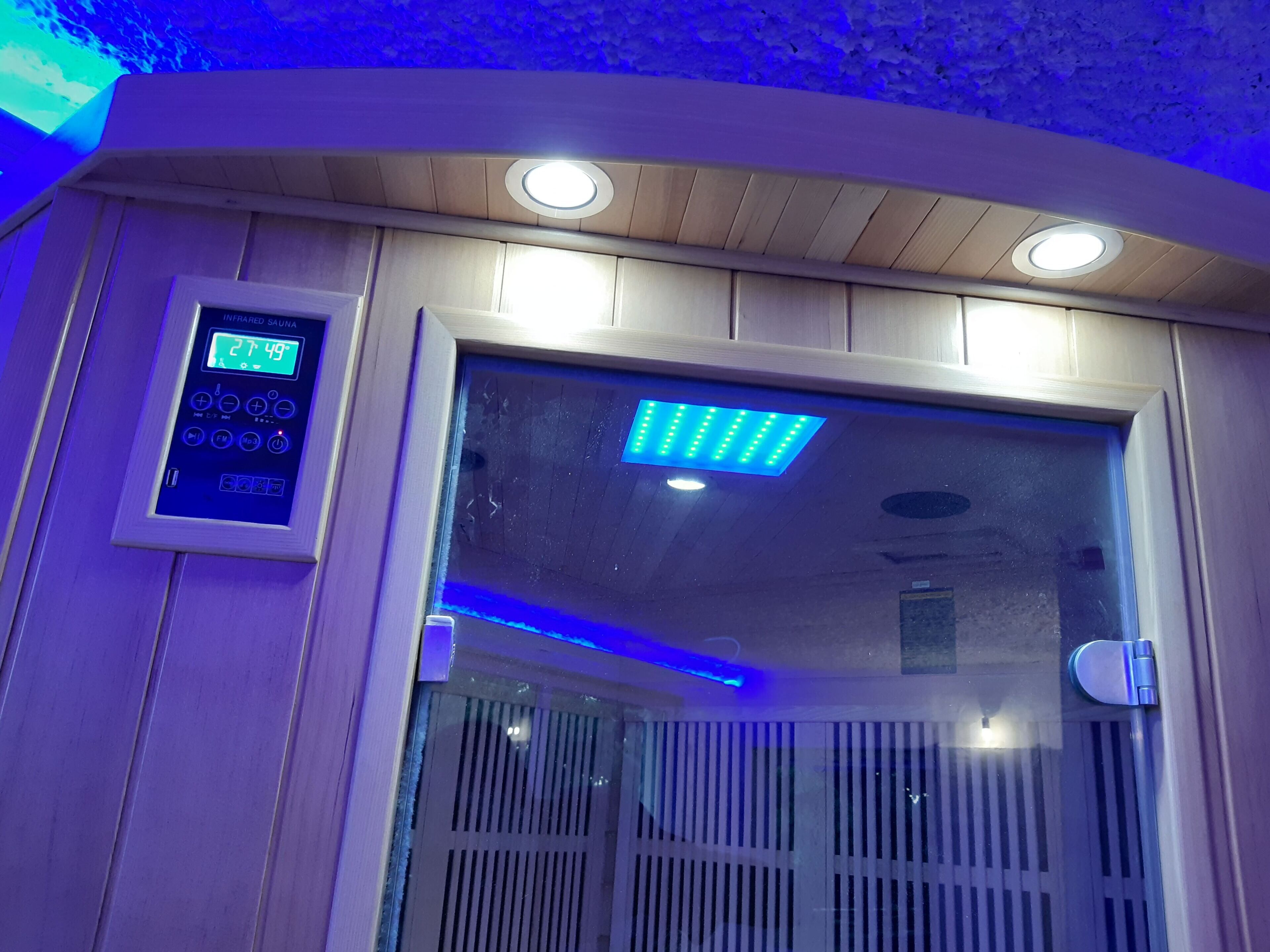 Uma sauna infravermelha com painel de controle exibindo temperatura e configurações de temporizador.