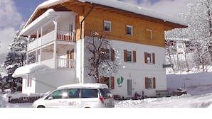 A two-story building with a balcony and a car parked in front. - Buchauer-Tirol Landhaus Buchauer (Thiersee)