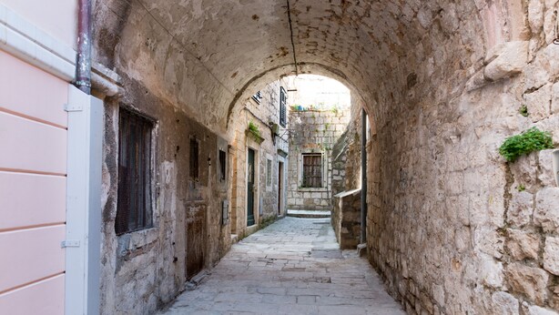 Un stretto vicolo in pietra con soffitti a volta e edifici su entrambi i lati.