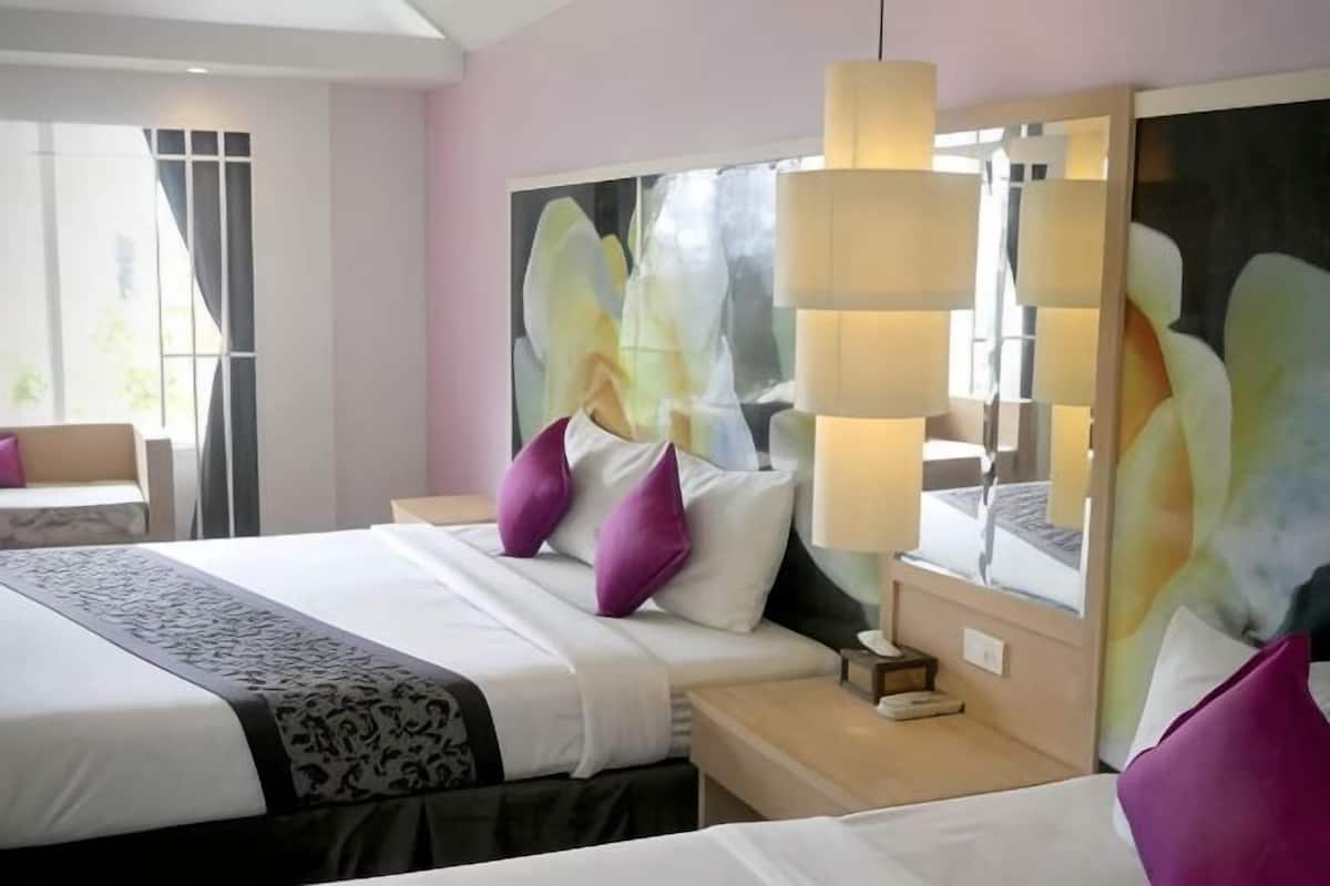 Une chambre d’hôtel avec un grand lit, des tables de chevet, un miroir et une fenêtre.